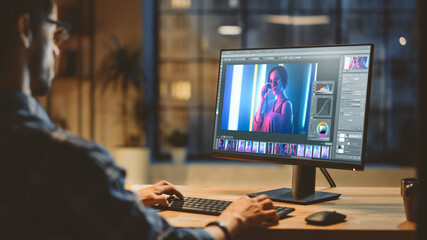 Over the Shoulder: Creative Young Digital Editor Works in Photo Editing Software on His Personal...