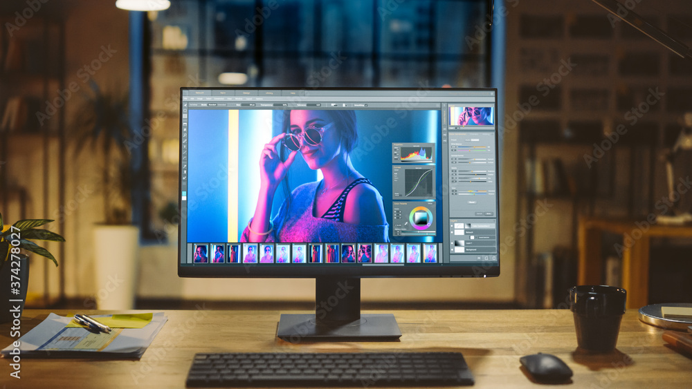 Poster Shot of a Desktop Computer in the Modern Office with Monitor Showing Photo Editing Software. In the Background Warm Evening Lighting and Open Space Studio with City Window View