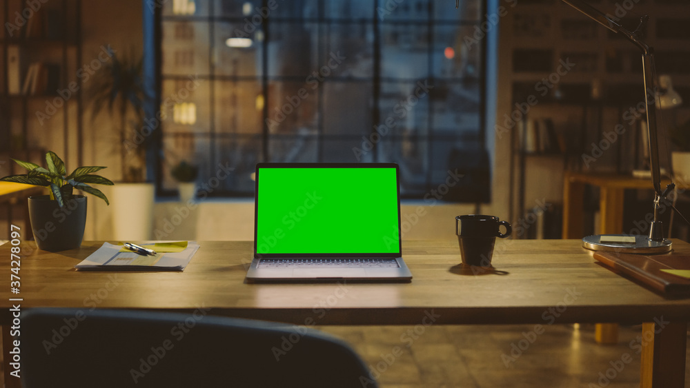 Aufkleber mock-up green screen laptop standing on the desk in the modern creative office. in the background wa