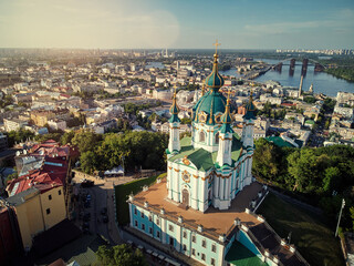 Fototapeta premium Aerial top view of Saint Andrew's church and Andreevska street from above, cityscape of Podol district, city of Kyiv, Ukraine