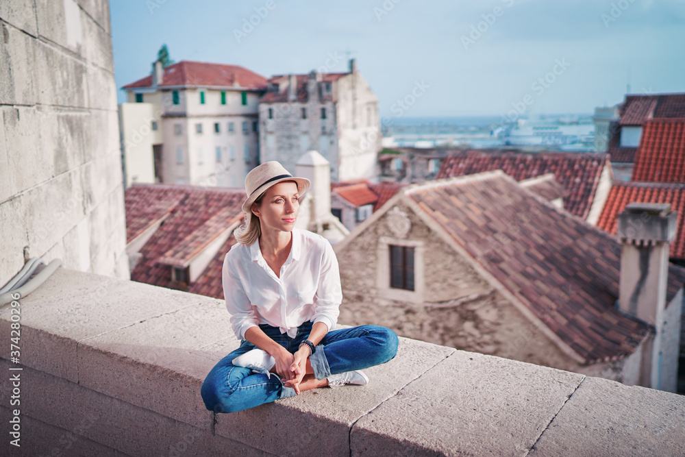 Sticker Traveling by Croatia. Young traveling woman enjoying old town Split view, red tiled roofs and ancient architecture.