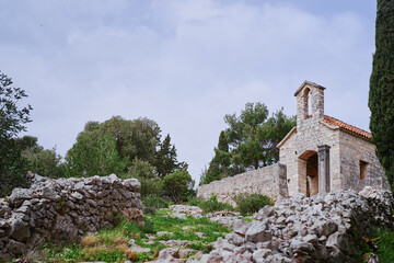 Ancient small catholic chapel made from stones with tiled roof.