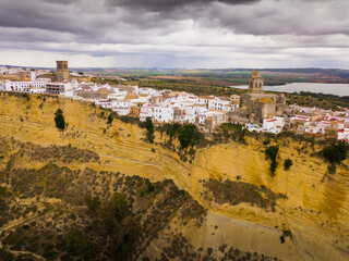 Aerial view of ancient city of Arcos de la Frontera located on edge of cliff on bank of Guadalete river, Andalusia, Spain..
