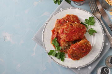 Vegetarian cutlets of peas and semolina in tomatoes sauce in a plate on blue background, Top view, Copy space