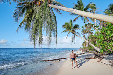 Young bearded man on the tropical sand beach.