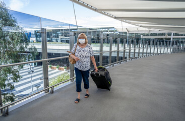 Fototapeta na wymiar Senior woman with mask worried to return home country due to quarantine .COVID-19 and travel