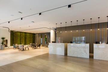 Interior of a hotel lobby with reception desks with transparent covid plexiglass lexan clear sneeze guards - obrazy, fototapety, plakaty
