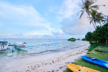 Colorful kayaks on the beach of island in Philippines. Tropical vacation and travel. Active tourism.