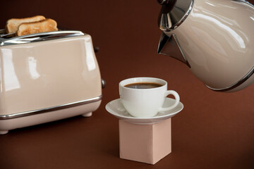 Cup of coffee on cube pedestal with toasts on brown