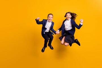 Fototapeta na wymiar Full length body size view of attractive small little crazy cheerful cheery ecstatic schoolkids jumping having fun great news reaction isolated over bright vivid shine vibrant yellow color background