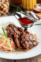 Grilled beef meat with rice and red sauce