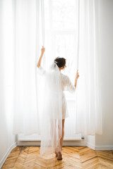 Portrait of beautiful bride with fashion veil at wedding morning