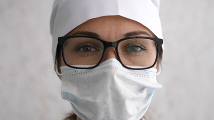 Female doctor in glasses looking straight at camera. Hard work, medical, epidemic concept