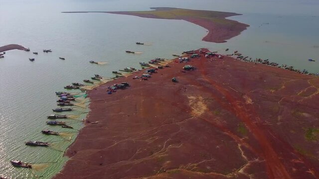 Aerial view of Ben Nom fishing village, a brilliant, fresh, green image of the green algae season on Tri An lake, with many traditional fishing boats anchored. Location in Dong Nai province, Vietnam