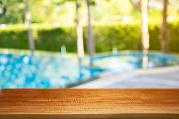 Fototapeta na wymiar Product show On a brown wooden table Outdoor swimming pool area