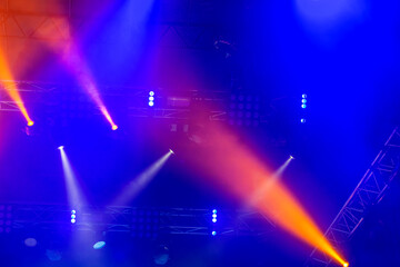 Fototapeta na wymiar Stage lights. Background in show. Light spotlight in the dark. The interior of the theater scene is illuminated to the projector. Stage lights and stage smoke during the concert