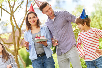 Eltern und Kinder feiern Geburtstag im Garten