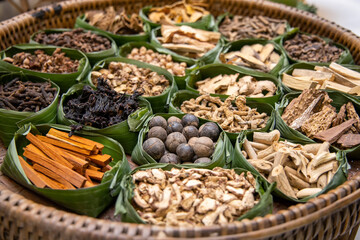 Asian dried herbs for alternative medicine therapy. Dried medicinal herbs in banana leaf tray for sacrificial offering of god in asian or thai traditional worship. 