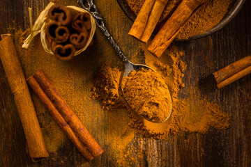 Cinnamon powder in vintage spoon with cinnamon sticks