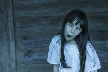 Scary ghost halloween theme. Horror devil girl with white eyes opens mouth and shouts