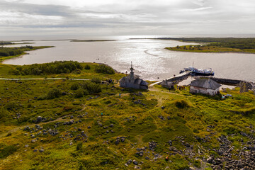 a panoramic view of an uninhabited island with an old church and ancient stone labyrinths filmed from a drone