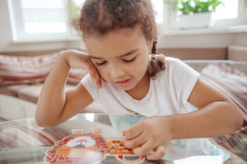 Cute baby girl or toddler playing with a puzzle, child development concept.