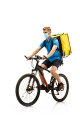 Obraz premium Deliveryman in face mask with bicycle isolated on white studio background. Contacless service during quarantine. Man delivers food during isolation. Safety. Professional occupation. Copyspace for ad.