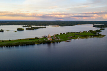 panoramic view of the lake with many islands on one of them there is an ancient temple made of wood at sunset filmed from a drone
