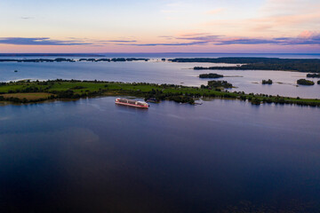 panoramic view of the lake with many islands on one of them there is an ancient temple made of wood at sunset filmed from a drone
