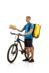 Obraz na płótnie Canvas Giving order. Deliveryman with bicycle isolated on white studio background. Contacless service during quarantine. Man delivers food during isolation. Safety. Professional occupation. Copyspace for ad.
