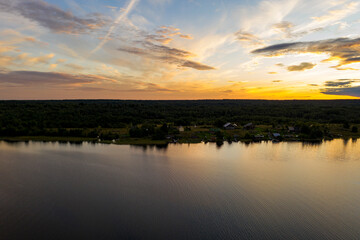 Fototapeta na wymiar panoramic view of the lake with many islands on one of them there is an ancient temple made of wood at sunset filmed from a drone