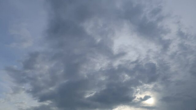 Dramatic b-roll TimeLapse of dark storm clouds & gray cumulus or cirrocumulus cloudscape slowly moved on bright sunrise sky with sun light rays & sunbeam shining through tropical summer horizon  
