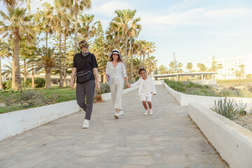 Mother and daughter walks along the seafront at the seashore  in the spring