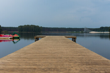 Wooden pier on a lake. Cloudy day in a holiday resort.