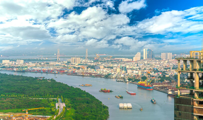 Fototapeta premium Panorama High view Saigon skyline when the sun shines down urban with tall buildings along river showing development of country in Ho Chi Minh City, Vietnam 
