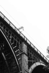 old railway bridge in black and white on an overcast day