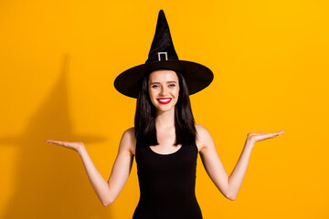 Photo of lovely pretty young magician lady shiny smile hold empty space presenting products equally...