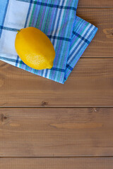 one lemon on a wooden cutting Board wooden table, kitchen towel
