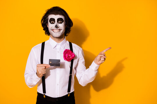 Portrait of his he nice handsome spooky cheerful cheery glad guy holding in hands plastic card money transfer showing copy space advert isolated bright vivid shine vibrant yellow color background