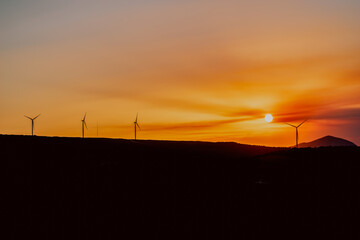 sunset in the town of Cañete La Real in Andalusia with the views of windmills and fields 