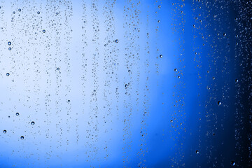 Naklejka na ściany i meble fresh drops background blue glass / wet rainy background, water drops transparent glass blue