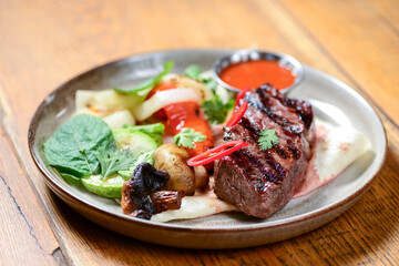 Grilled beef steak with grellied vegetables on a plate on the table. Horizontal top view. Georgian cuisine concept.