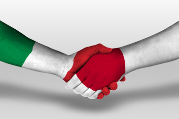 Handshake between japan and italy flags painted on hands, illustration with clipping path.