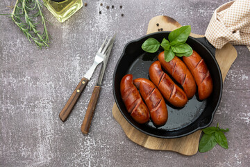 Roasted delicious sausages on a frying skilette pan, meat sausages for breakfast.