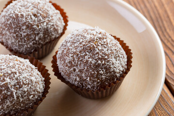 Fototapeta na wymiar Chocolate balls in coconut shavings close up