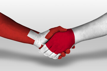 Handshake between japan and switzerland flags painted on hands, illustration with clipping path.