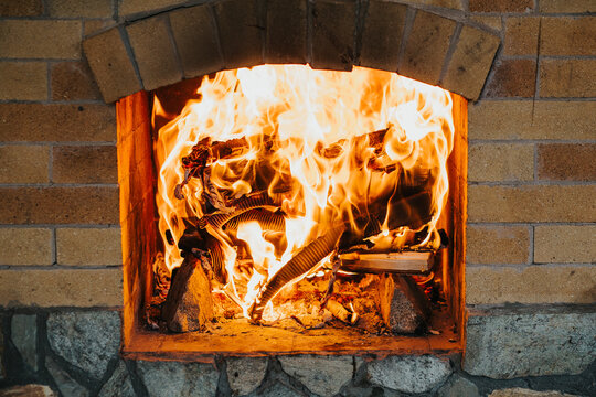 Fire burns in a brick fireplace. Close-up photo of a flame. Home comfort. High quality photo