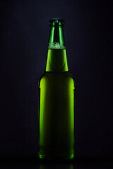 Green bottle of beer on a dark background