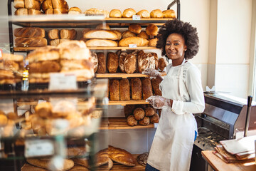 She will have you coming back for more. Gorgeous young woman in her bakery smiling cheerfully to...