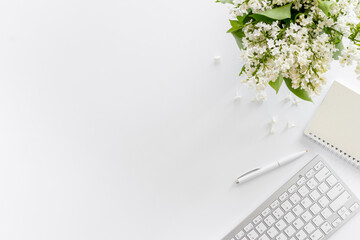 Top view of working space with jasmine flowers and computer keyboard